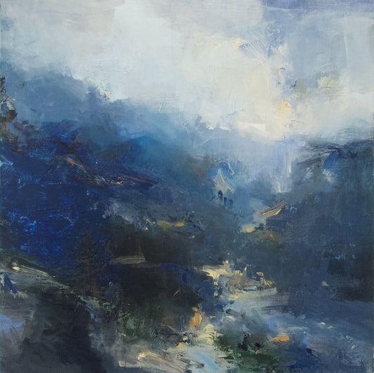 Dark blue hills with yellow lights and pale sky