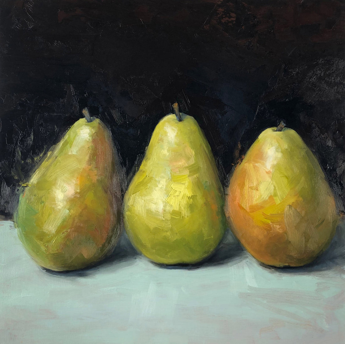 Three green and orange pears on dark background