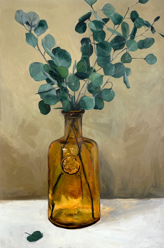 Orange glass vase with dried eucalyptus